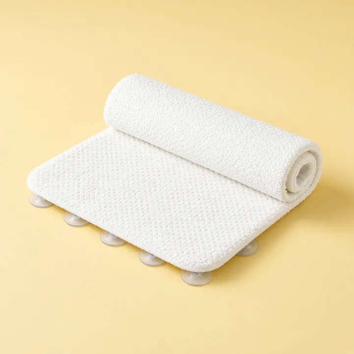 Rolled white textured non-slip bath mat with suction cups